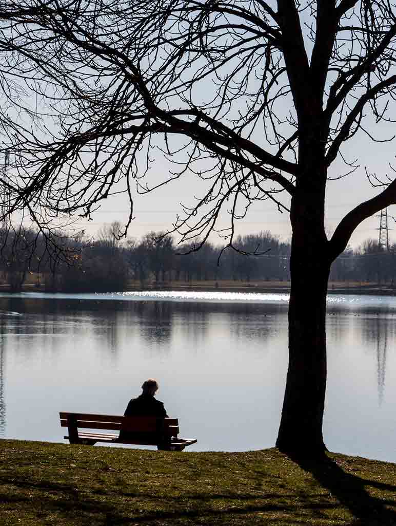 Person sitting alone by the waterfront